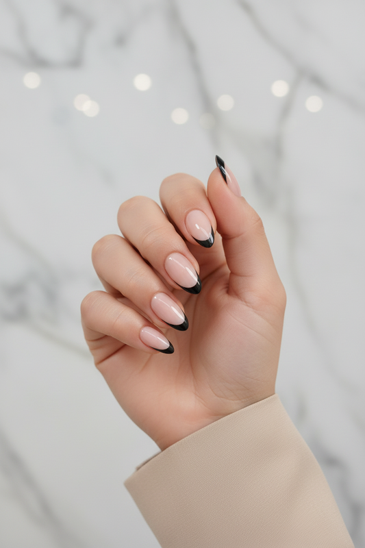 Hand with black swan clawture press on false nails pink and black nail polish against a blurred background