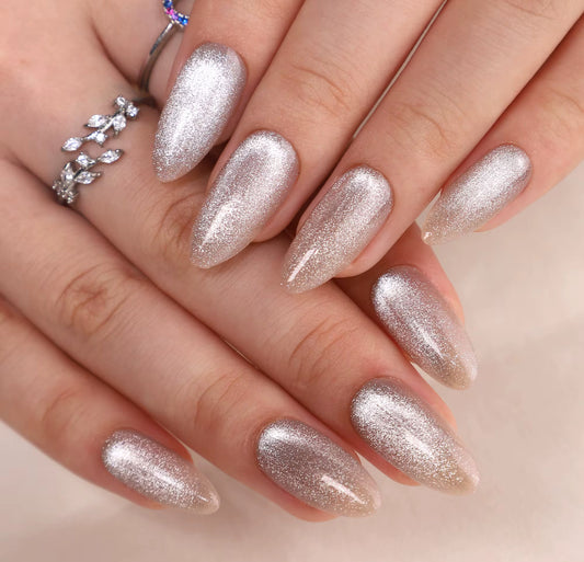 Close-up of a hand with glittery silver nails on a neutral background clawture cloud dust press on nails