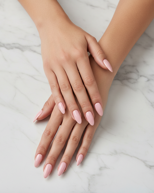 Close-up of hands with nude glam clawture press on nails pink nail polish on a marble surface