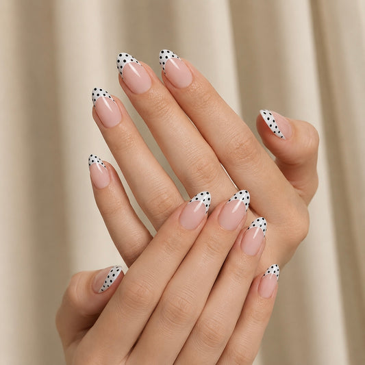 Close-up of a hand with polka dot Clawture Polka Blanc french tip false press on nails on a neutral background