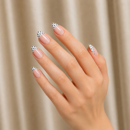 Hand with polka dot Clawture Polka Blanc french tip false press on nails on a beige background