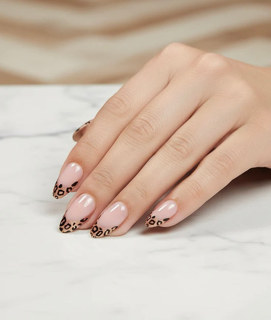 Hand with pink nails and leopard print design Clawture Wild French tip false press on nails on a neutral background