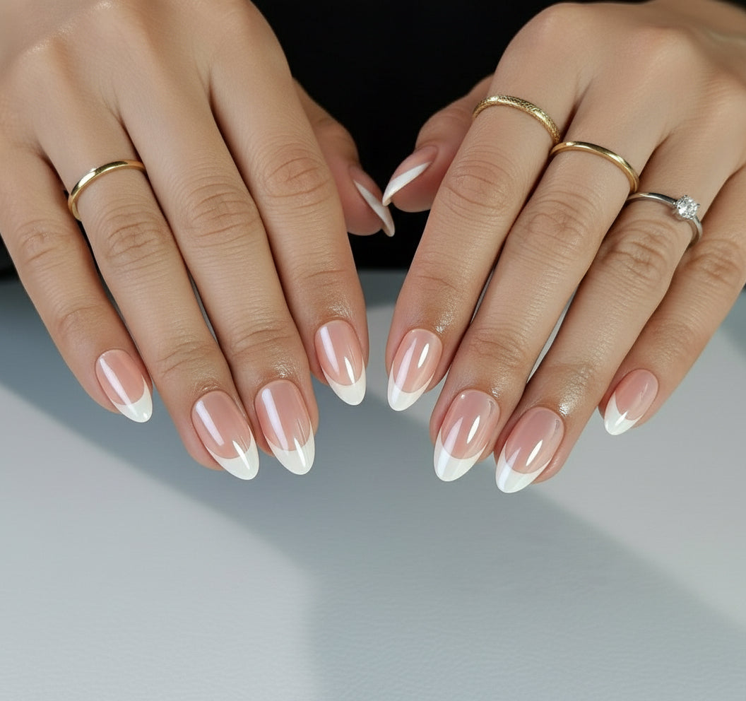 Close-up of hands with Clawture Glowish classic nude press on nails and gold rings on a neutral background