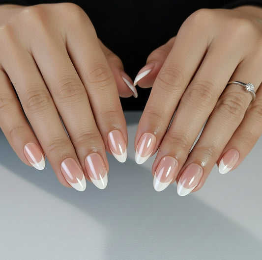 Close-up of hands with Clawture Glowish classic nude press on nails and gold rings on a neutral background