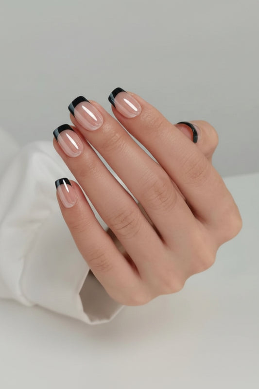 Hand with black french tip black edge clawture press on nails on a neutral background
