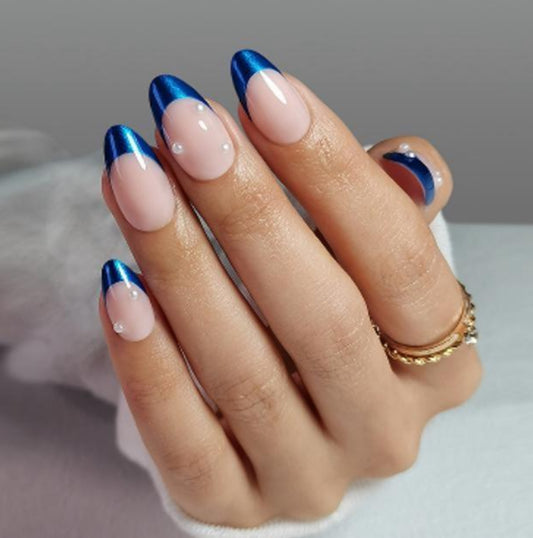 Hand with blue and pink blueberry clawture press on nails on a neutral background