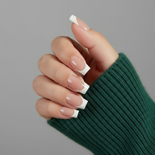 Hand with white french tip clawssic clawture press on nails on a gray background