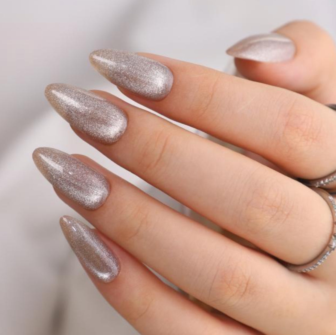 Hand with glittery silver nails on a neutral background clawture cloud dust press on nails 