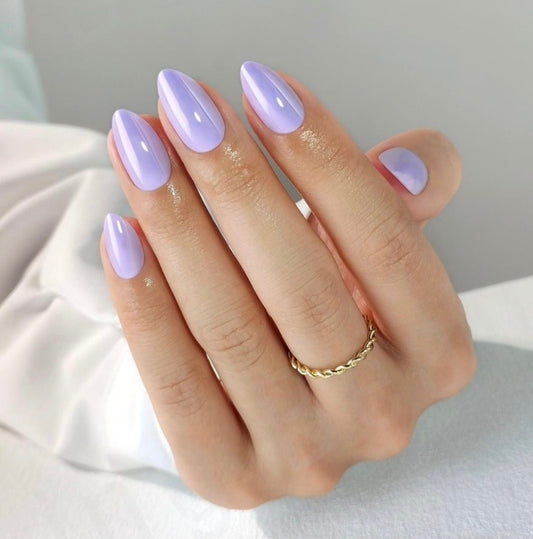 Hand with clawture lavender dream press on false nails nail polish on a neutral background