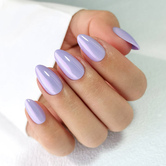 Hand with clawture lavender dream press on false nails lavender-colored nail polish on a light background