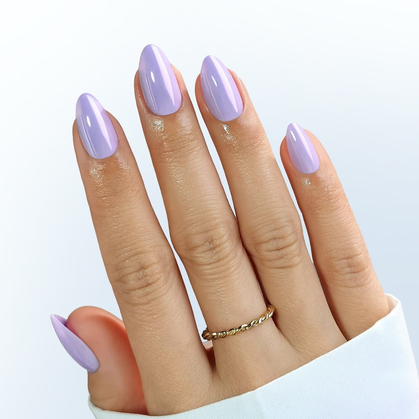 Hand with clawture lavender dream press on false nails on a light blue background