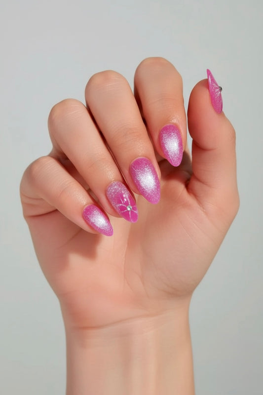 Hand with flowertine clawture press on false nails pink glittery nail polish on a plain background