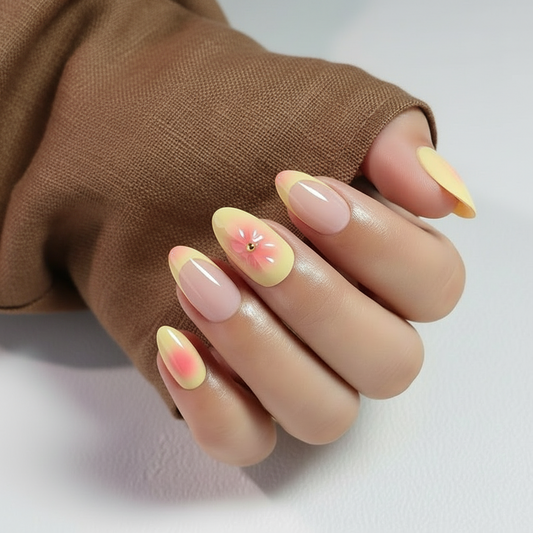 Clawture Sunset Bloom press on nails with a gradient design held by a brown sleeve on a light background
