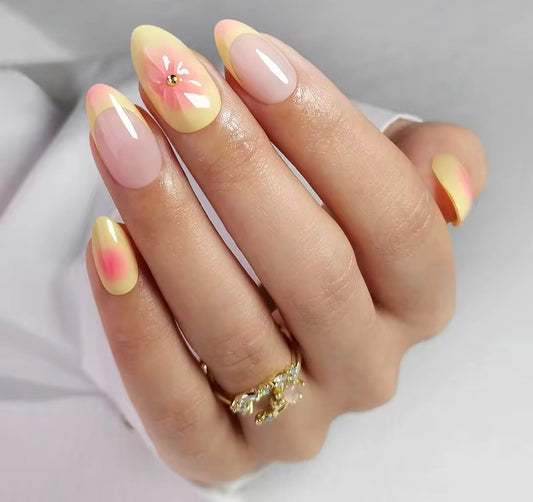 Hand with Clawture Sunset Bloom press on nails wearing a white sleeve on a light background