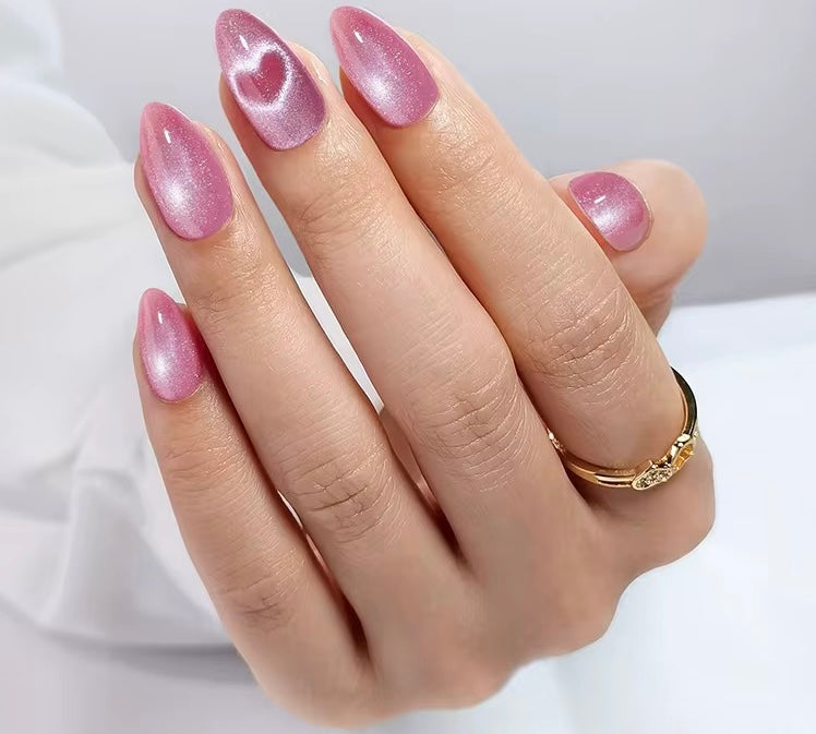 Hand with pink vat eye and heart nails on a white background valentine clawture press on nails